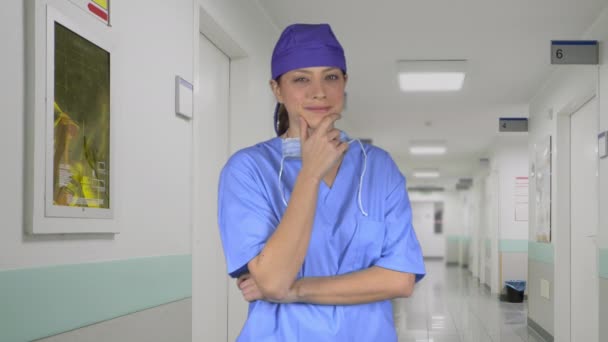 Glada kvinnliga läkare w / hand på hakan i hallen — Stockvideo