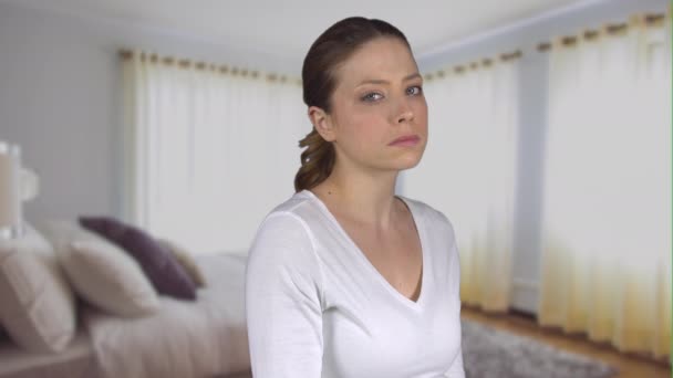 Triste femme regarde en caméra dans une chambre — Video