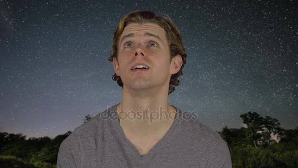 El hombre mira por encima de la cabeza en el cielo nocturno — Vídeos de Stock