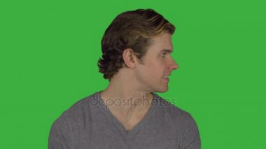 Güzel görünümlü adam döner ve gülümsüyor (yeşil anahtar)