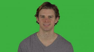 Huzurlu görünümlü adam sırıtıyor kamera (yeşil anahtar)