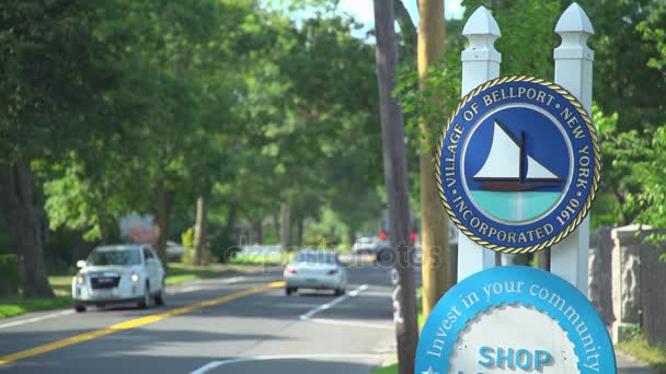 Cars driving by the town sign for Bellport, NY — Stock Video