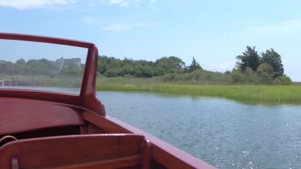 Houten boot drijvend in de buurt van de kust grassen — Stockvideo