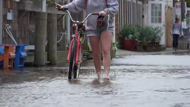 Kvinna med cykel i en översvämning — Stockvideo