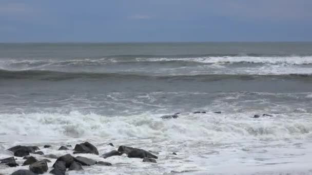 Грубые волны плескаются на скале — стоковое видео