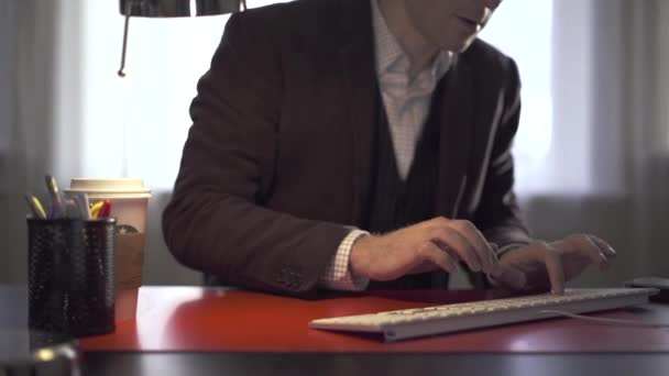 Человек печатает, а затем поднимает свой телефон — стоковое видео