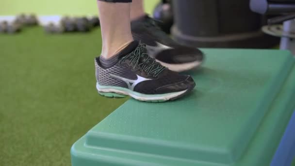 Feet of a woman doing step aerobics — Stock Video