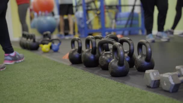 Verschiedene Menschen, die in einem Fitnessstudio Gewichte heben — Stockvideo
