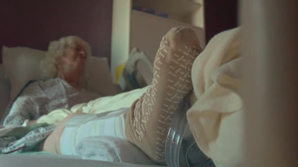 Долли снимок спящего пожилого пациента с заменой колена — стоковое видео