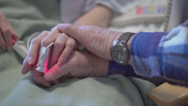 Elderly married couple holding hands in hospital — Stock Video