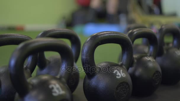 Shallow DOF shot of weights with man working out — Stock Video