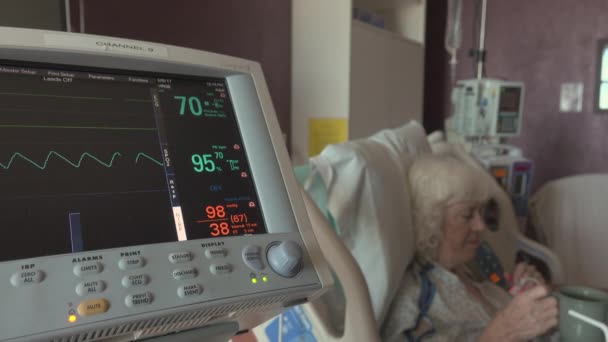 Heart monitor with happy elderly patient nearby — Stock Video