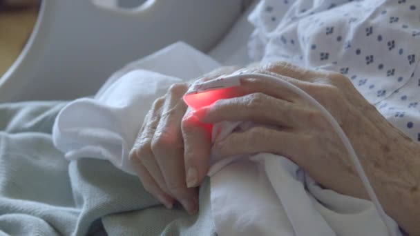 Detalj av hjärtat bildskärm som är ansluten till äldre kvinnas finger — Stockvideo