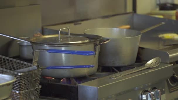 Llamas de gas bajo una olla grande en una cocina — Vídeos de Stock