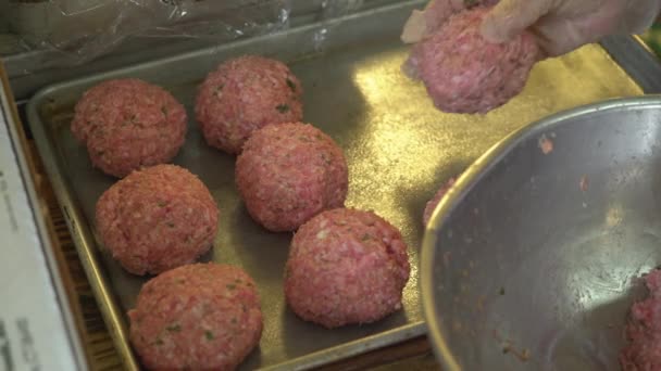 Cook förlägger raw köttbullar på en kastrull — Stockvideo