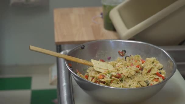 Большую миску салата с макаронами помешивают — стоковое видео