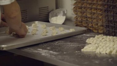 İtalyan baker kurabiye hamuru tepsi koyar.