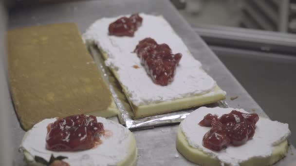 Baker extiende la capa de relleno de fruta en un pastel — Vídeo de stock
