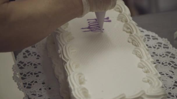 Baker scrivere Buon compleanno su una torta personalizzata — Video Stock