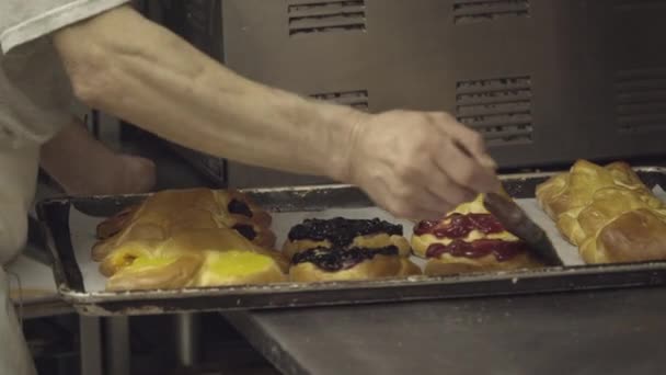 Baker finishing batch of pastry — Stock Video