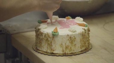 Baker havuç doğum günü pastası üzerinde yazıyor