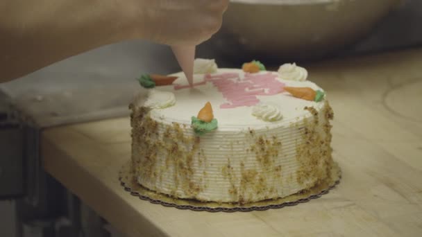 Baker pisze na tort urodzinowy marchew — Wideo stockowe
