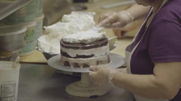 Chocolate cake being frosted by baker — Stock Video