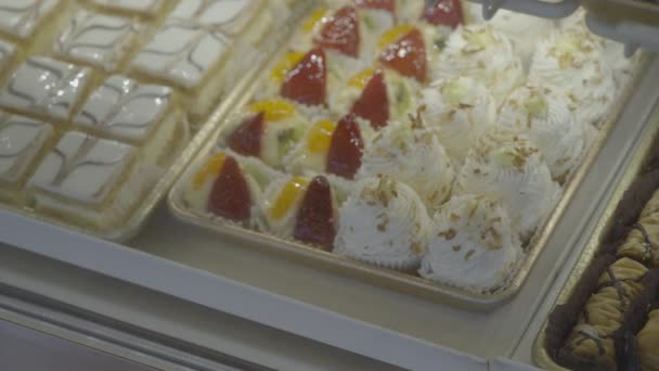 Delicate taarten en berijpte cake geplaatst in geval — Stockvideo