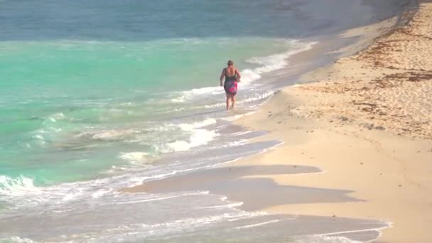 カンクンのビーチの上を歩く遠い人 — ストック動画