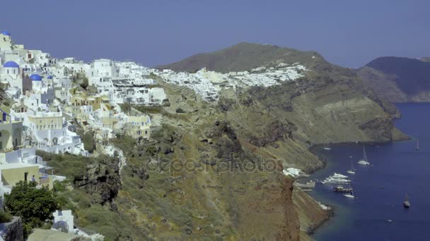 Widok na łodzie zacumowane na wybrzeże poniżej Santorini — Wideo stockowe