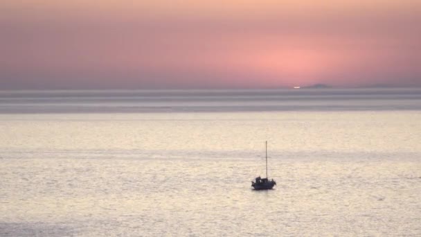 Sun drops below horizon near fishing boat at sunset — Stock Video