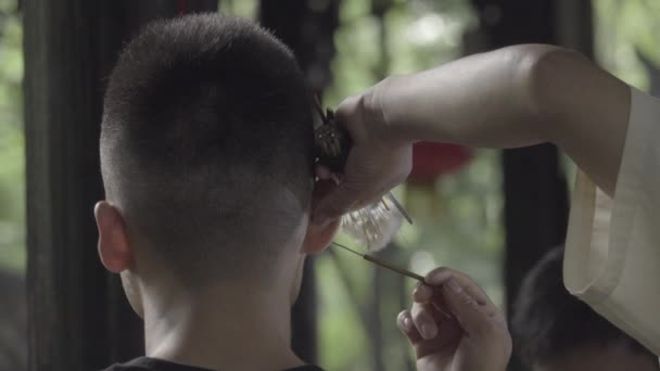 Man recieves a customary Chengdu ear cleaning — Stock Video