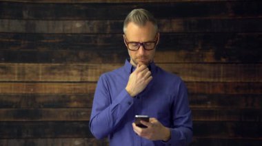 Telefon aygıt ve ciddi görünüyor kullanan düşünceli adam