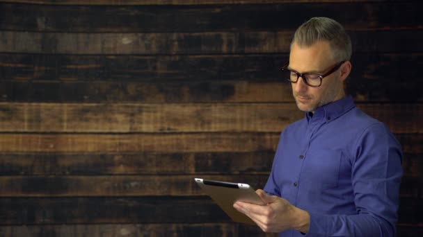 El hombre reflexivo usando tabletas gira y sonríe — Vídeos de Stock