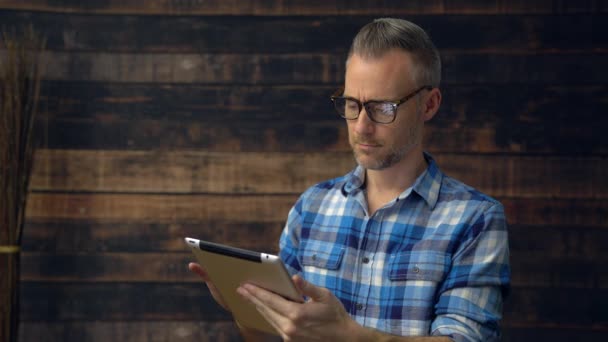 Geruite dragen man gaat door het lezen van — Stockvideo