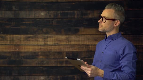 Homme avec dispositif regarde hors caméra puis au spectateur — Video