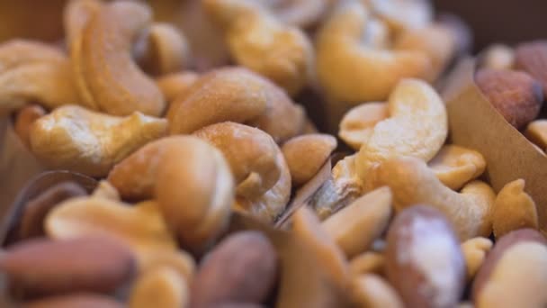 Сортированные орехи выливаются в другие орехи — стоковое видео