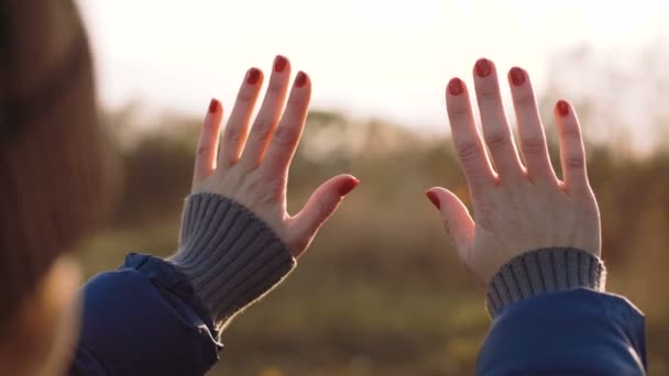 Menina olha para o sol através de sua mão — Vídeo de Stock