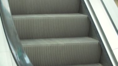 Yürüyen merdiven aşağı hareket. Yürüyen merdiven inen bir adamın bacaklar.