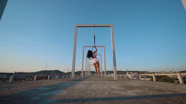 Воздушная гимнастика женщина висит на воздушном обруче на крыше с прекрасным видом — стоковое видео