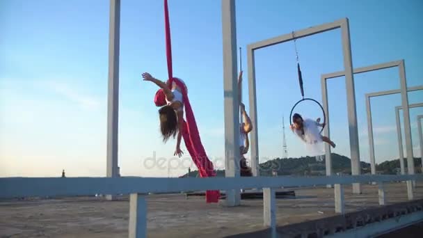 Tre vackra sexig tjej utför akrobatiska stunts på taket med fin utsikt. — Stockvideo