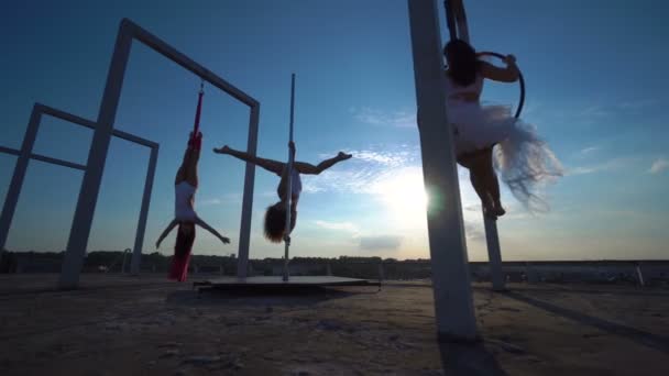 Tres hermosa chica sexy realizando acrobacias en el techo con una bonita vista . — Vídeo de stock