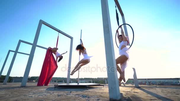 Üç güzel seksi kızı performans gösteren akrobatik stunts güzel manzaralı çatıda. — Stok video
