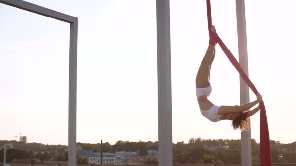 Tres hermosa chica sexy realizando acrobacias en el techo al atardecer . — Vídeos de Stock