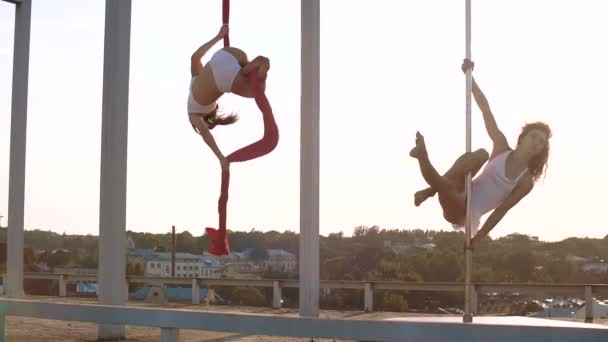 Üç güzel seksi kızı performans gösteren akrobatik stunts batımında çatıda — Stok video
