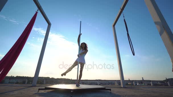 Three beautiful sexy girl performing acrobatic stunts on the roof with a nice view and looking at the camera. — Stock Video