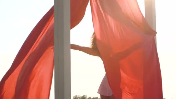 Beautiful sexy girl with aerial silk looking to the camera on the rooftop. aerial silk beautifully waving in the wind — Stock Video