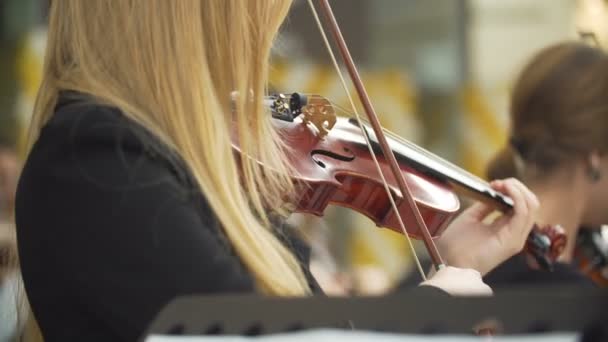 Krásná dívka si hraje na housle s orchestrem. — Stock video