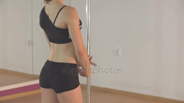 Porträtt av en vacker pole dansare flicka som ser in i kameran och visar musklerna — Stockvideo