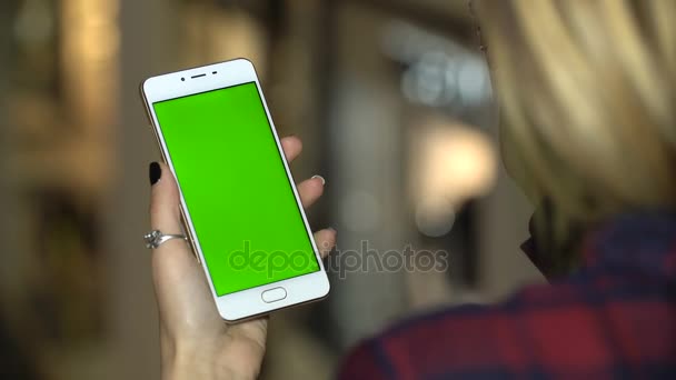 Жінка використовує мобільний телефон в торговому центрі з зеленим екраном, дотиком і прокруткою — стокове відео